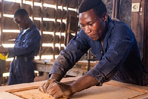 Daniel Chamba Louis taking part in a CAJED carpentry workshop with other local young men